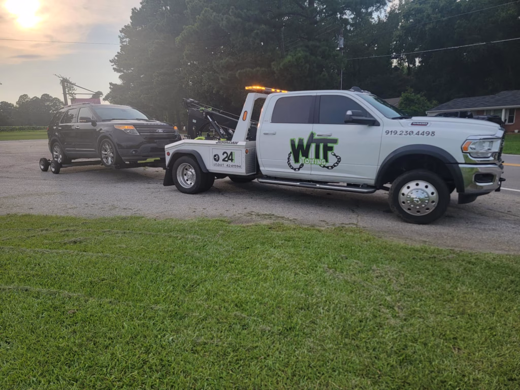 WTF Towing Ram wrecker with a truck in tow on a grass lot