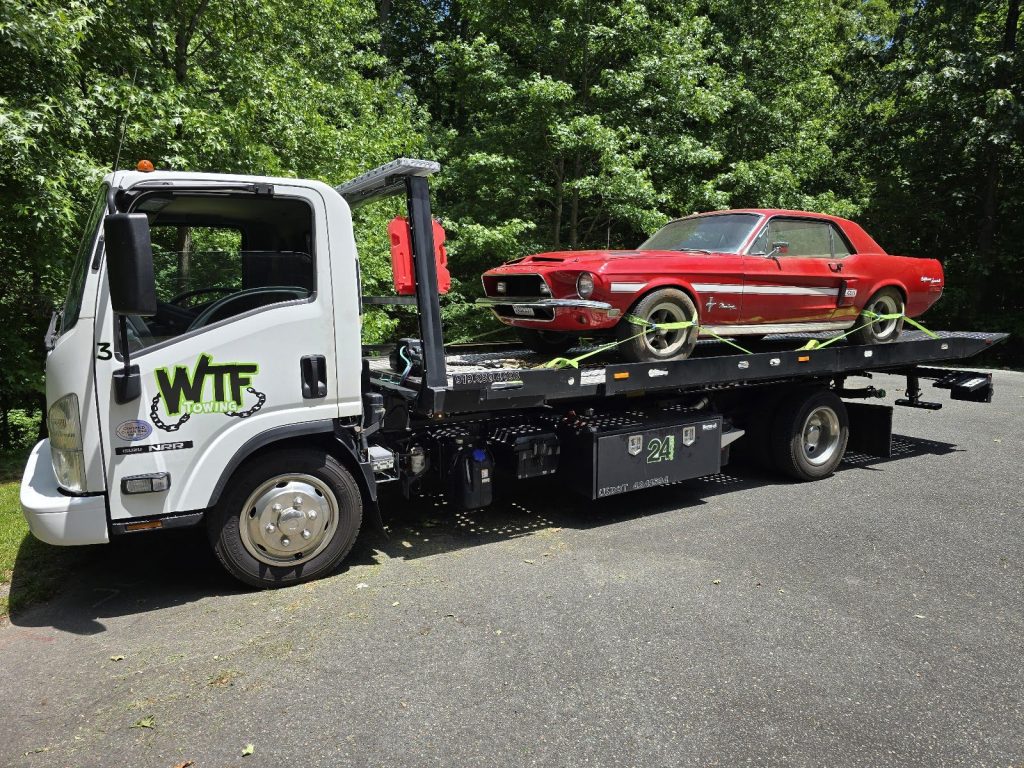 WTF Towing flatbed with a red classic Mustang strapped down, Cary, NC