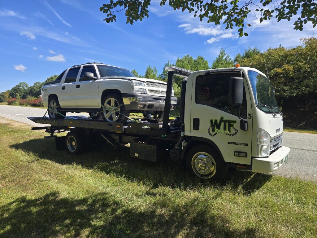 WTF Towing rollback with a Chevy Avalanche loaded on a Cary, NC roadside