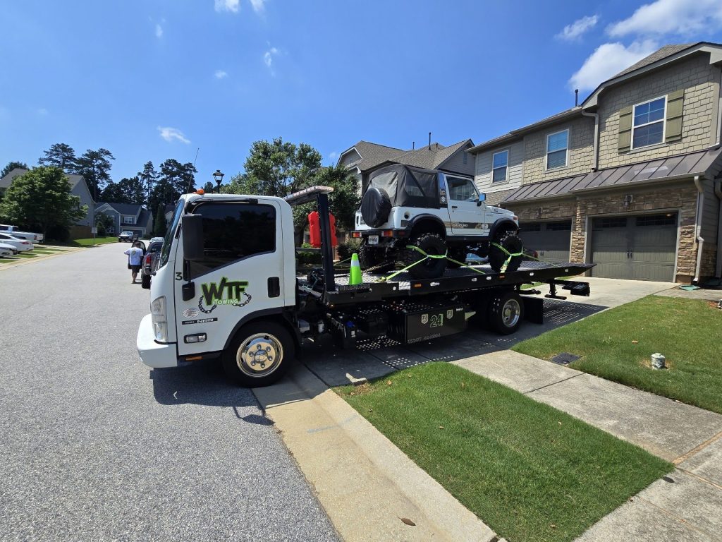 WTF Towing rollback loading a Jeep from a Cary, NC driveway
