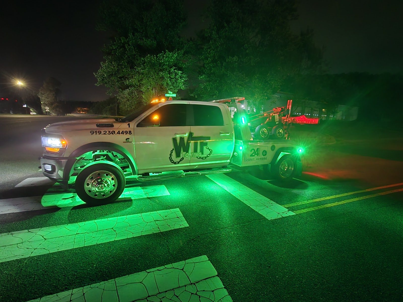 WTF Towing wrecker lit up at night in Cary, NC