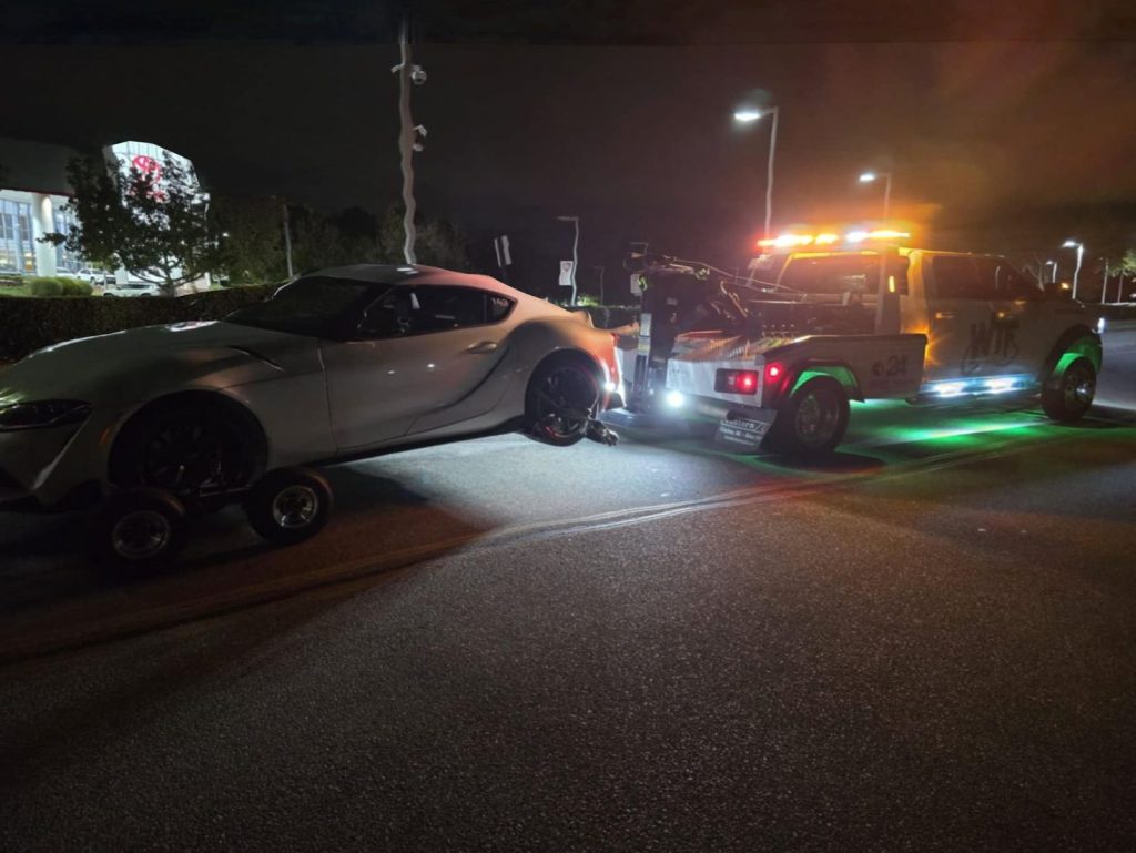 WTF Towing wrecker loading a sports car at night near RDU Airport