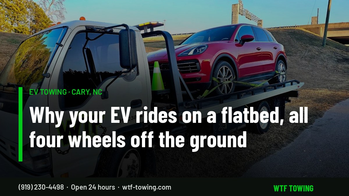 WTF Towing rollback carrier hauling a red SUV strapped down on its flatbed with all four wheels off the ground - EV towing in Cary, NC