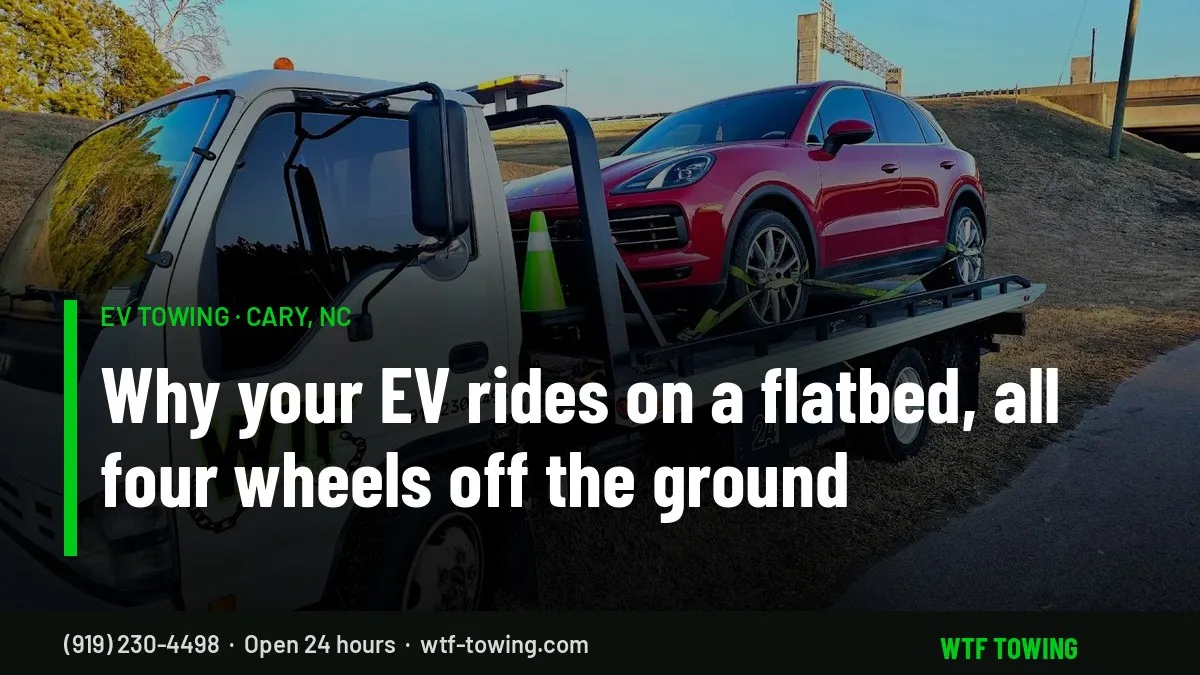 WTF Towing rollback carrier hauling a red SUV strapped down on its flatbed with all four wheels off the ground - EV towing in Cary, NC