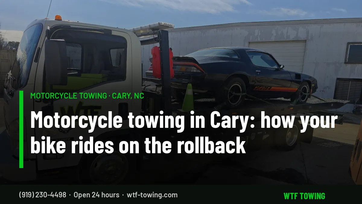 WTF Towing Isuzu rollback carrier with a black sports car strapped down at four points on its flatbed - motorcycle towing in Cary, NC rides on this bed